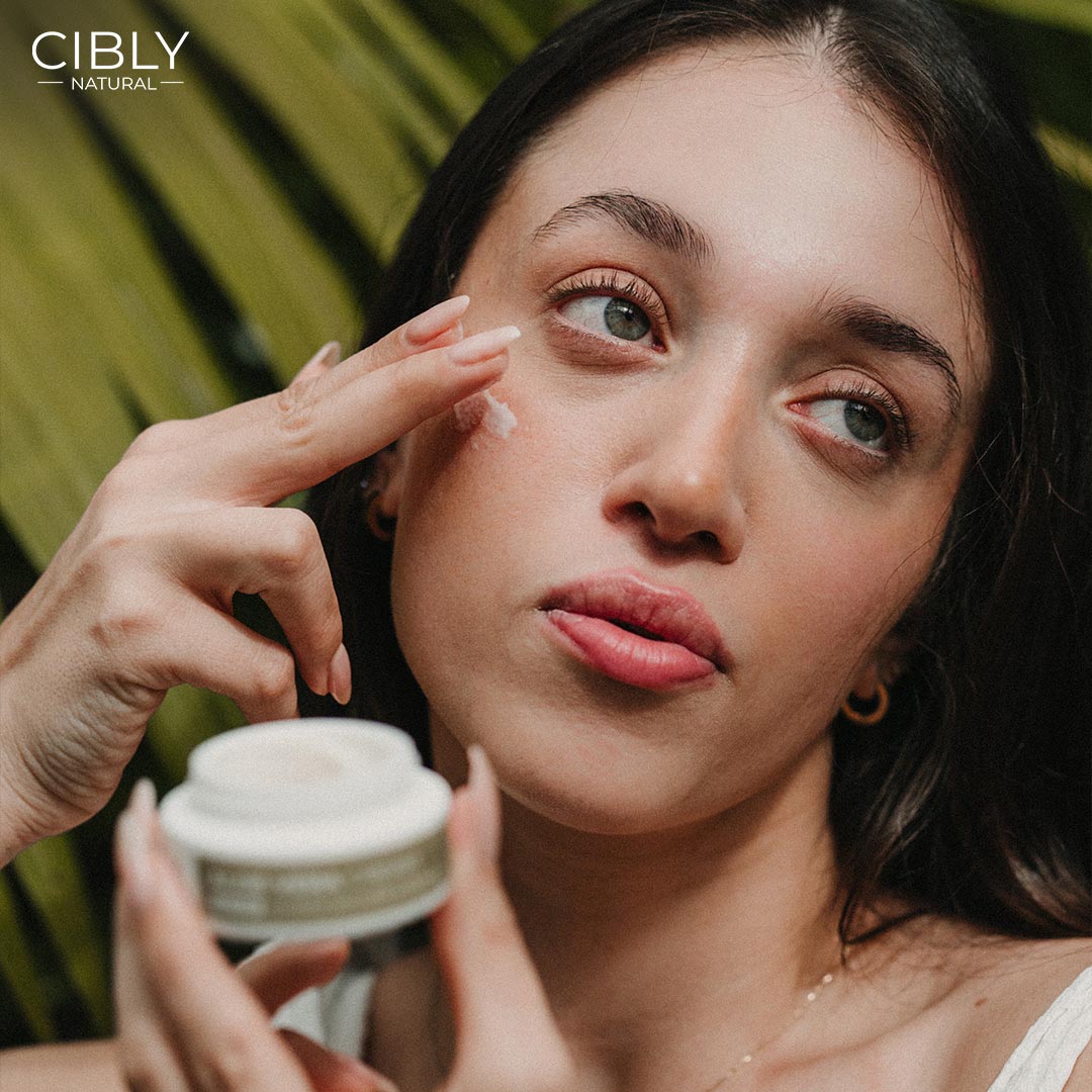 Жена нанася крем върху лицето си – CIBLY ритуал за красива кожа